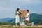 Offer in the mountains. A guy puts a ring on his bride while standing on his knee. Happy couple. Marry me. Good luck