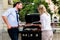 Office colleagues grilling sausages at bbq after work