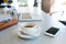 Office desk with coffee cup, smartphone and laptop.