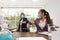 Office employees in masks greeting each other by bumping elbows at workplace