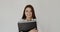 Office girl with folder in hands looks and smiles at camera on white background