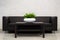 Office Interior Element: White Pot Of Green Houseplant Spathiphyllum On Dark-Brown Table Near A Black Leather Sofa. Green Office P