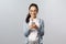 Office lifestyle, business and people concept. Happy cheerful korean woman texting friend, use mobile phone, smiling at