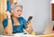 Office lifestyle portrait of attractive worried and stressed middle aged Asian woman using mobile phone at laptop computer desk