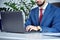 Office manager in modern office typing on laptop keyboard