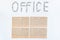 Office object. The word office, faded on a white background with metal stationery clips. The concept of office work