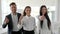 Office people with thumbs up at boardroom, three managers showing positive gesture close-up, multinational business