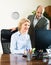 Office scene with two elderly and positive workers