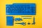 Office suplies painted in classic blue color over yelow background. Study, education, creative office desktop idea