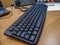 Office table with black computer wired keyboard. Closeup