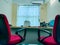 An office table and chairs with a big window behind the boss\'s chair