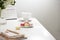 Office table desk. Feminine desk workspace frame with calendar, diary, hortensia bouquet, macaron and coffee on white background.