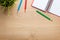 Office table with flower, blank notepad and colorful pencils