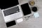 Office table with laptop computer, digital tablet, pen, smartphone, mouse, eyeglasses and coffee on white wood background