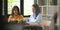 Office women are working with computer laptops while sitting together.