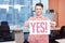 Office worker holding poster with yes slogan