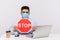 Office worker in hygienic mask holding red Stop sign warning of contagious coronavirus epidemic, quarantine