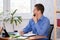 Office worker joyfully looks out the window while waiting for the weekend