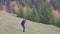 Office worker launches a quadcopter on a hill in the summer in front of the forest