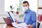 Office worker in medical mask examines data in documents with amazement