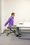 Office worker sitting on kneeling stool, stretching arms