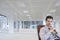 Office worker sitting in swivel chair hands clasped in empty office space