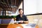 Office worker sorting papers on table near laptop.