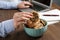 Office worker taking chocolate chip cookie from bowl at workplace, closeup