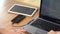 Office worker using computer and wired smart phone charging on table. closeup