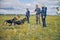 Officers training detection dogs in grassy field
