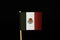 A official flag of Mexico on toothpick and on black background. Mexico belongs between the most criminality land in the world. Dru