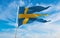 official flag of Naval Ensign of Sweden, Sweden at cloudy sky background on sunset, panoramic view. Swedish travel and patriot