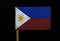 A official flag of the Philippines on toothpick on black background. A horizontal bicolour of blue and red with a white