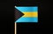 A official national Flag of the Bahamas on wooden stick on black background. The state located on north america