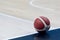 An official orange ball on a hardwood basketball court