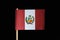 A official and original flag of Peru on toothpick on black background. A vertical triband of red and white with the national coat