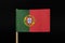 A official and original flag of Portugal on toothpick on black background. A vertically striped bicolour of green and red, with