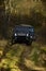 Offroad race in autumn forest. SUV or two black offroad cars on fall nature background. Car racing extreme and four