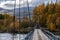 Offroad suv cross the river through vintage rustic suspension bridge. River crossing concept. Old rope bridge.