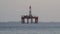 Offshore oil platform drilling site or oil rig project seen far in the middle of the sea