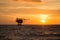 Offshore oil and rig platform in sunset or sunrise time. Construction of production process in the sea. Power energy of the world