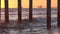 Offshore oil rigs seen from under a pier at sunset