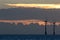 Offshore wind farm turbines silhouette at sunrise or sunset