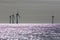 Offshore wind farm wind turbines silhouette. Focus on sea horizon