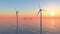 Offshore wind turbines and cargo ship at sunset