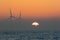 Offshore wind turbines. Misty morning sea sunrise. Tropical back