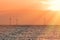 Offshore wind turbines. Pastel orange sunrise sky soft background image