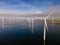 Offshore windmill park with clouds and a blue sky, windmill park in the ocean drone aerial view with wind turbine