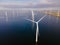 Offshore windmill park with clouds and a blue sky, windmill park in the ocean drone aerial view with wind turbine