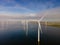 Offshore windmill park with clouds and a blue sky, windmill park in the ocean drone aerial view with wind turbine